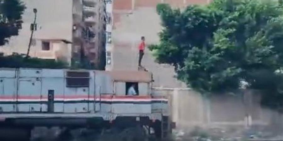 بالبلدي : فيديو مثير لشاب يقف أعلى مقدمة القطار خلال سيره.. والسكة الحديد تعلق | صور